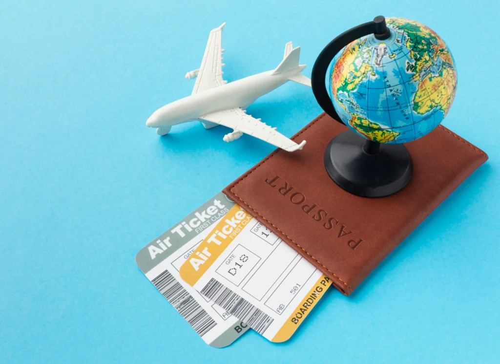 Passport, boarding pass, and toy airplane with a globe on a blue background, representing the step-by-step abroad visa consultation process offered by the best visa consultants in Ahmedabad, including initial consultation, document preparation, application submission, and follow-up.