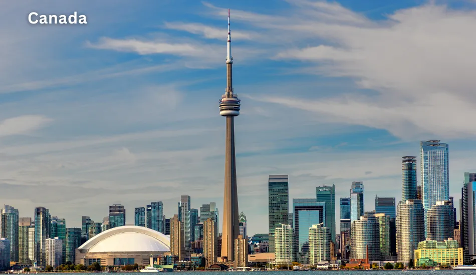 Skyline view of Toronto with the CN Tower and Rogers Centre under a blue sky, showcasing Canada as one of the best countries to migrate for healthcare access, immigrant-friendly policies, and future career opportunities in healthcare and IT.