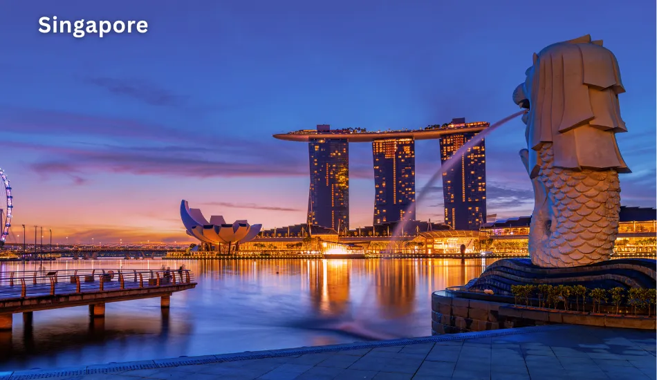 Night view of Singapore’s Marina Bay Sands and Merlion statue, symbolizing Singapore as one of the best countries to migrate for a strong economy, global job market, world-class infrastructure, and a safe, tax-friendly environment.