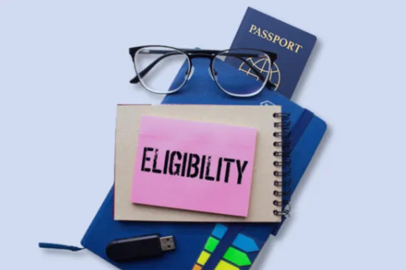 Notebook labeled "Eligibility" with passport, glasses, and USB drive, symbolizing key USA student visa criteria like I-20 form, financial proof, English proficiency, and DS-160 form, guided by the best USA study visa consultant in Ahmedabad